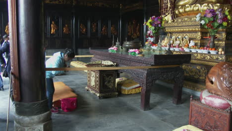 a tall buddha stands in a chinese buddhist temple