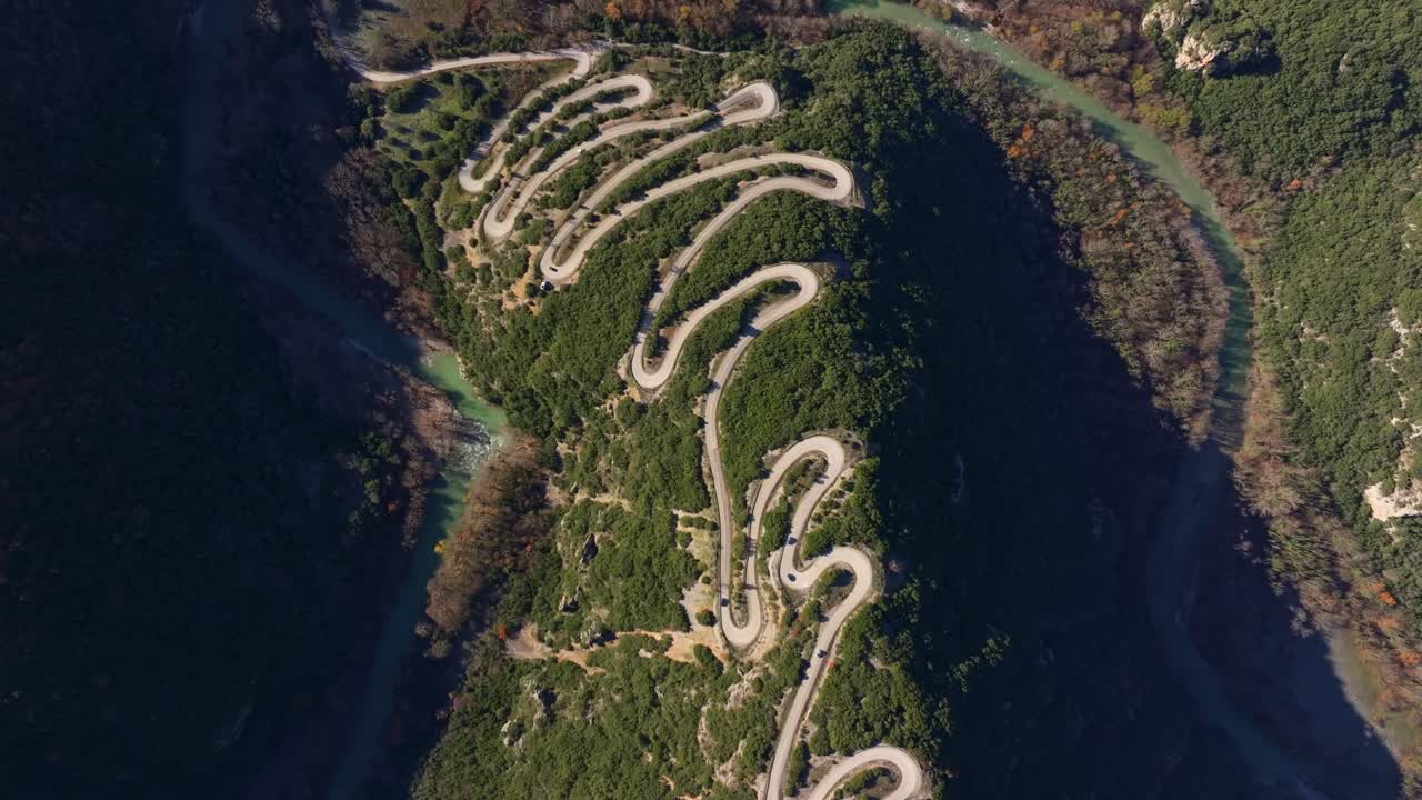 Drone image of lush mountain pass with twisting road, Greece