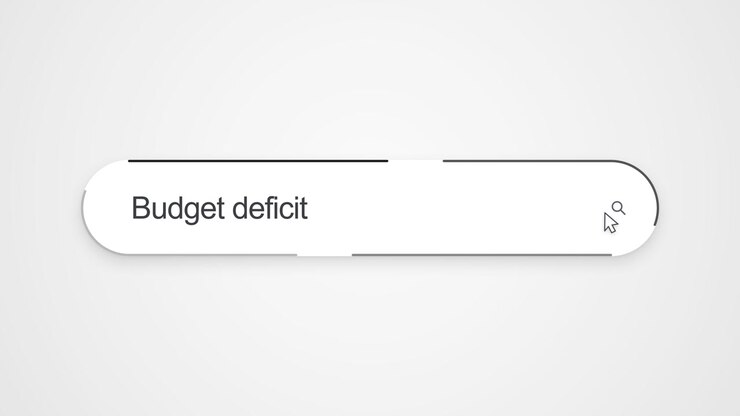 Primo piano della digitazione di "Deficit di bilancio" in una barra di ricerca online con un cursore posizionato vicino all'icona di ricerca, a illustrazione della ricerca finanziaria e delle informazioni economiche