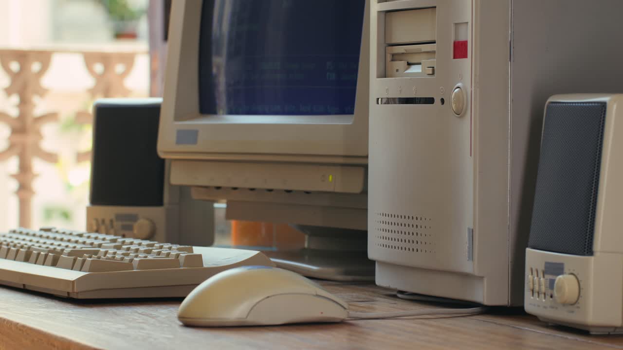 Man working and gaming on retro computer PC, IT engineer with vintage computer at home, using old fashion technology, close up of retro setup.
