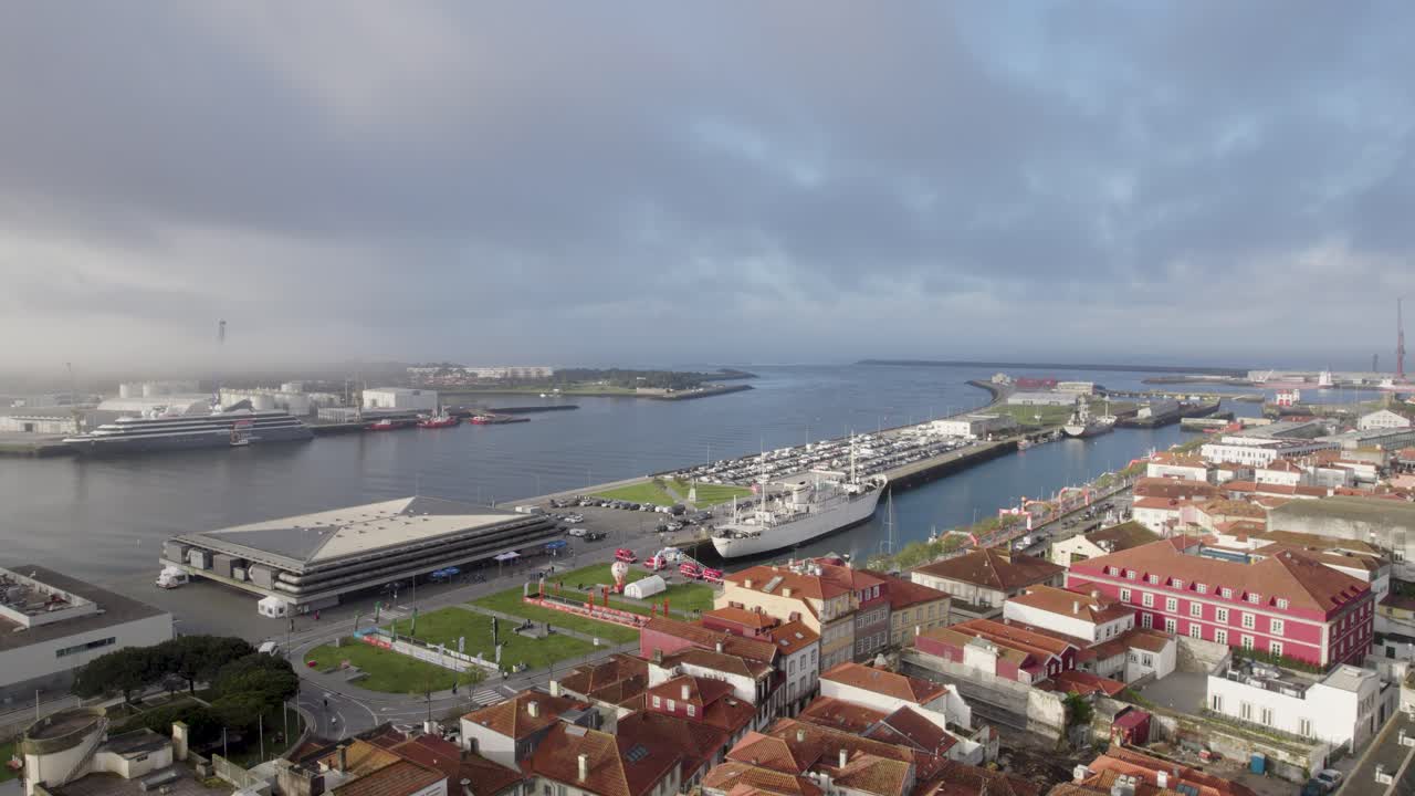 Aerial panorama of Viana do Castelo harbor showing the marina, cruise terminal, shipyard cranes, and historic waterfront buildings in northern Portugal