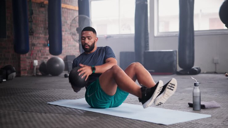 Man doing crunches with an exercise ball in a gym