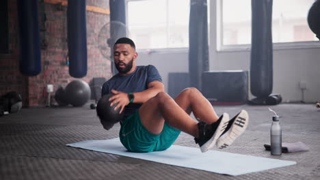 man doing crunches with an exercise ball in a gym