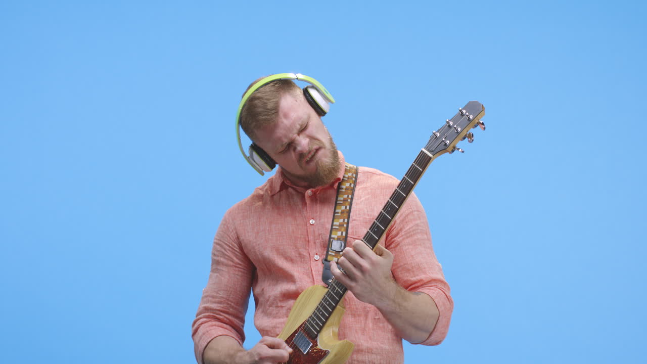 Man Playing Guitar with Headphones