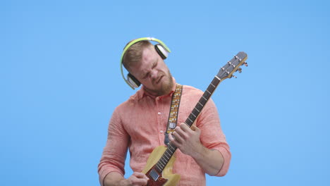 man playing guitar with headphones