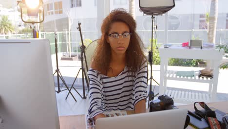 female photographer using laptop in photo studio 4k