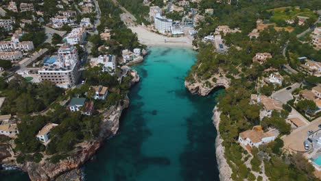 Clear-turquoise-blue-sea-water,-remote-natural-bay-with-white-sand-beach,-luxury-hotel-villa