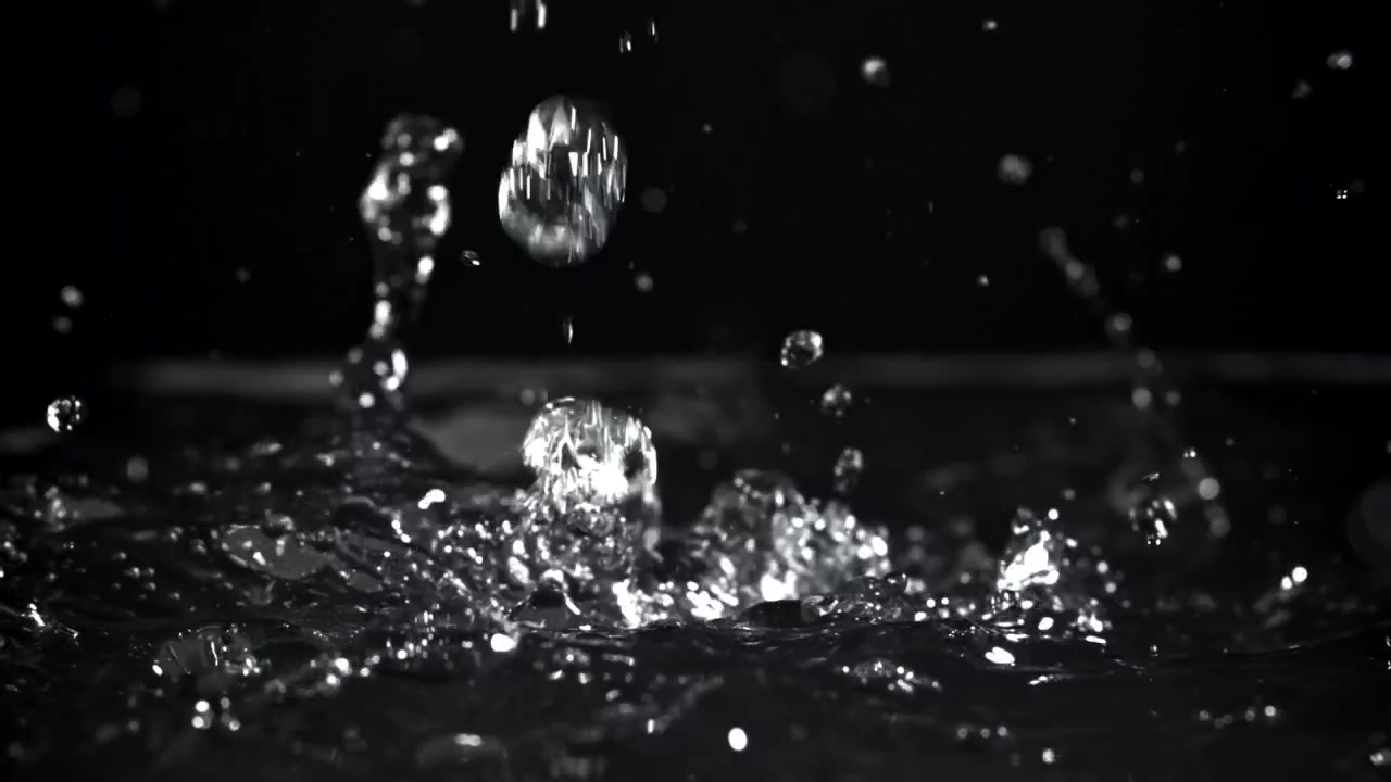 Slow Motion Water Drops Splashing on a Dark Surface