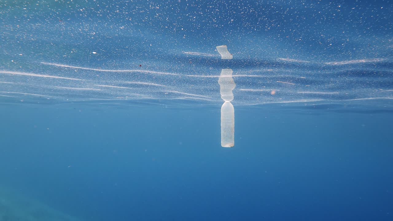 A Plastic Bottle Floating In The Blue Ocean - Environmental Pollution. - medium shot