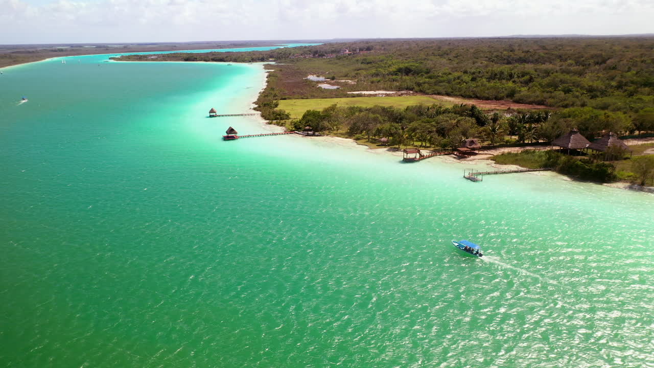 hermosa toma de drones de aguas turquesas en bacalar mexico con un bote en el agua