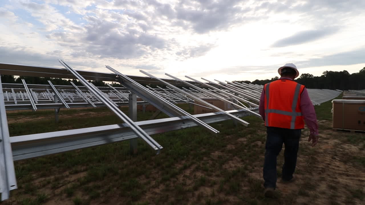 campo de paneles solares en construcción, con trabajadores de la construcción, caminando y siguiendo el tiro