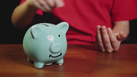 boy saving money concept. kid put money in a piggy bank