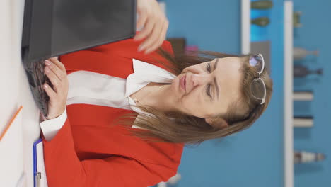 Vertical-video-of-Home-office-worker-woman-working-on-laptop-stressed.