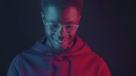 man using smartphone in neon lighting