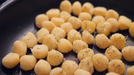 stunning close up of homemade gnocchis being fried in big pan