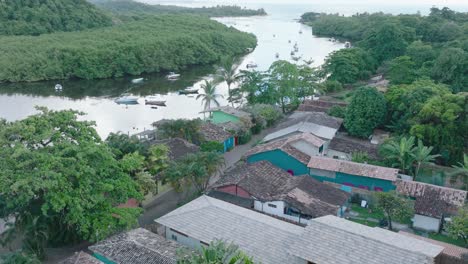 Luftaufnahme-Der-Ländlichen-Strandstadt-Caraiva-Bahia-Brasilien-Von-Oben-Nach-Unten,-Die-Mit-Booten-über-Baumwipfel-Und-Den-Fluss-Fliegt