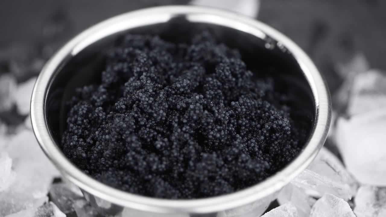 порция черной икры, вращающаяся на тарелке (близко; беспрерывная петля)