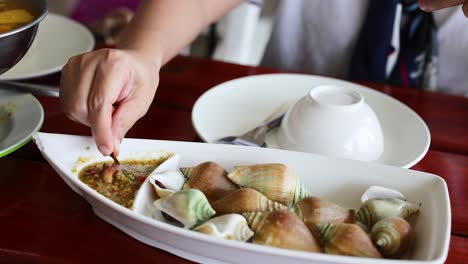 hand picking seafood from a dish