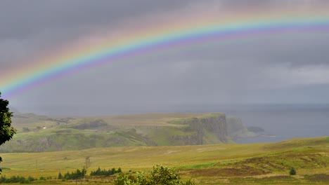 Arco-Iris-Sobre-Prados-Y-Acantilados-En-La-Isla-De-Skye-En-Escocia-Con-Nubes