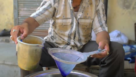 man filtering blue dye