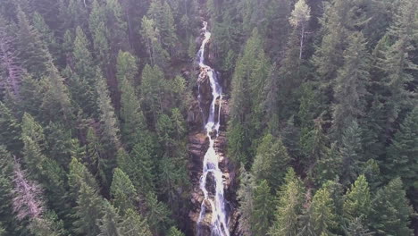 Drohnenaufnahme,-Die-Einen-Bergwasserfall-Hochschwenkt,-Der-In-Einem-Wald-Eingebettet-Ist,-In-4k