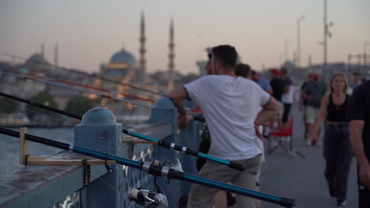 People fishing on a bridge in Istanbul are chatting with each other as they cast their lines