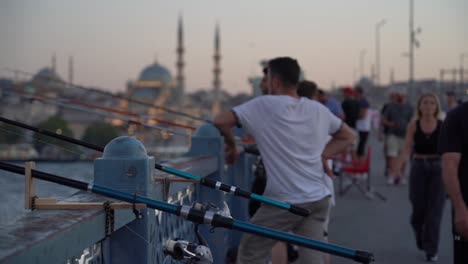 people fishing on a bridge in istanbul are chatting with each other as they cast their lines