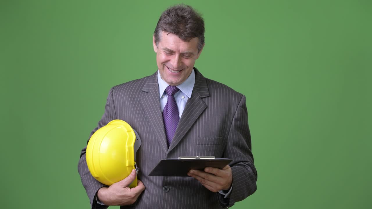 hombre de negocios maduro y guapo contra un fondo verde