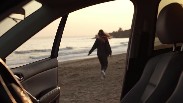 Femme courant de manière détendue de la voiture vers la plage, se sentant enthousiaste sur la plage.