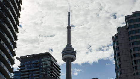 timelapse of mostly cloudy sky behind iconic cn tower in toronto