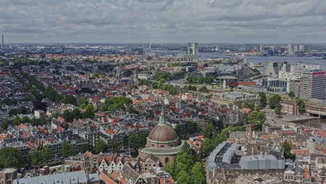 Amsterdam,-Países-Bajos,-Drone-V6-Aéreo-Que-Vuela-Alrededor-De-La-Iglesia-De-La-Cúpula-Capturando-El-Paisaje-Urbano-Del-Centro-Rodeado-Y-El-Sistema-De-Canales-En-El-Centro-De-La-Ciudad-Y-Los-Vecindarios-Del-Cinturón-De-Canales-Al-Oeste---Agosto-De-2021