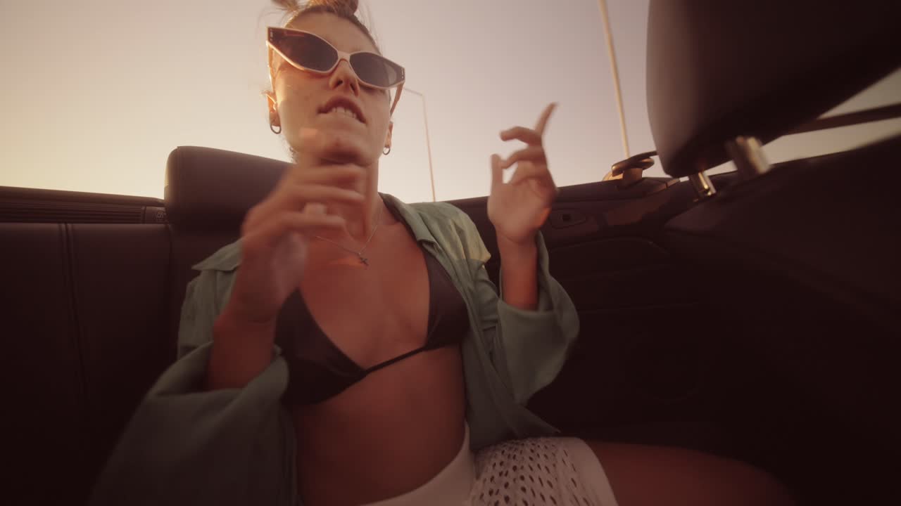 A woman in a convertible is enjoying a summer road trip