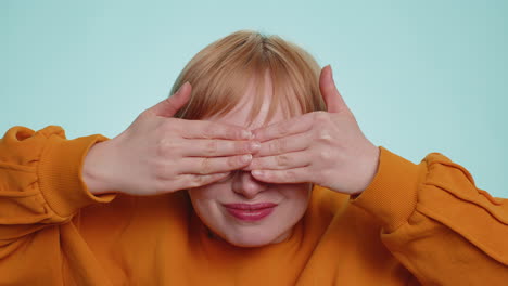 Nosy-curious-young-woman-closing-eyes-with-hand-and-spying-through-fingers-hiding-and-peeping