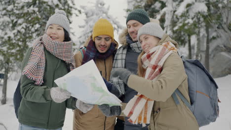 friends looking at a map in a snowy forest