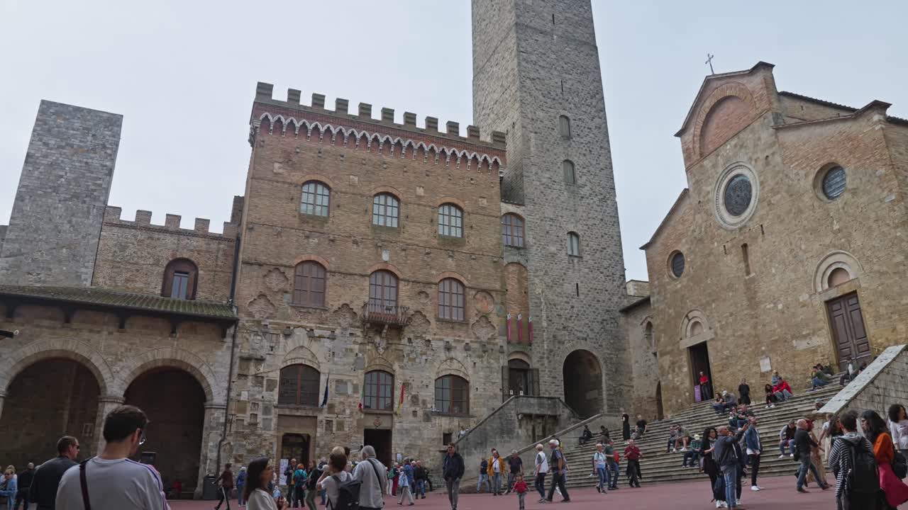 varios turistas en la famosa plaza del duomo en la histórica ciudad de san gimignano, toscana, italia