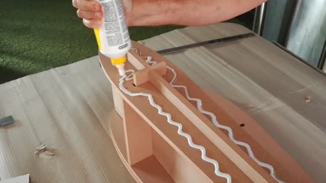 close-up-of-a-hand-applying-wood-glue-to-micro-fiberboard