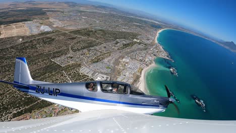 Kleines-Flugzeug-Fliegt-über-Die-Küste-Mit-Tafelberg-Und-Strand-Im-Hintergrund