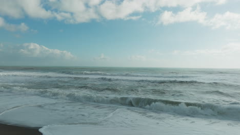 waves of ocean crashing furiously on the shore during cold winter