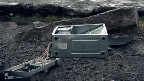 computadora rota en la orilla del río
