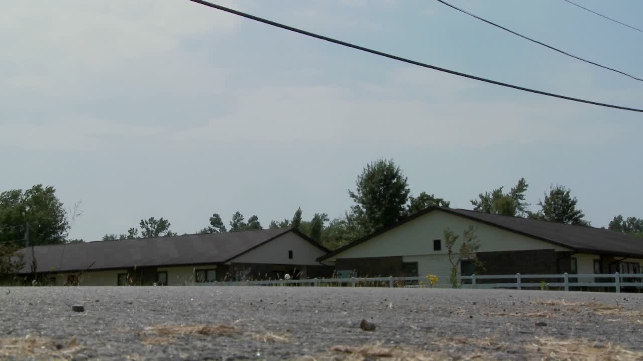 un ángulo bajo de un carro amish de caballos y buggy moviéndose a lo largo de un camino rural
