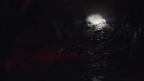 hombre explorando una cueva con una llamarada roja