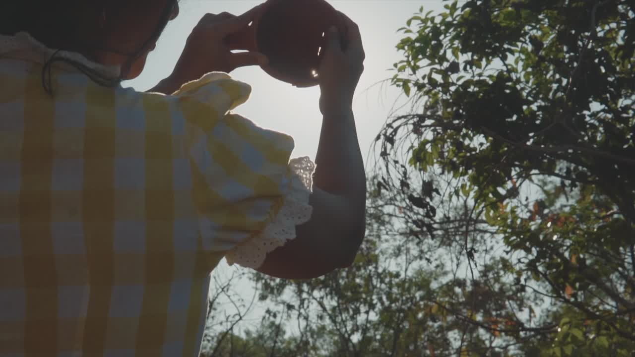 깨진 찻주전자를 수리하고 조각난 도자기를 햇빛에 맞대고 모은 여성