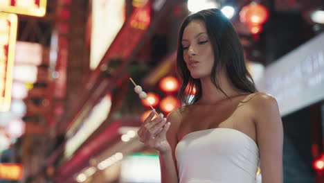 woman eating street food in a night market