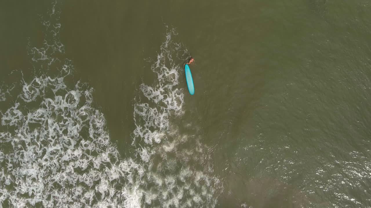 vista de pájaro de una surfista en el golfo de méxico frente a la costa del lago jackson en texas