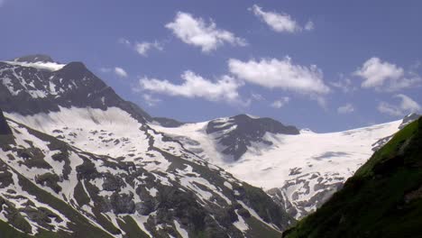 clouds float over snowy mountains