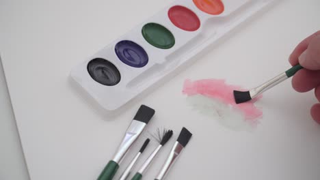 los pinceles y los dolores de acuarela se utilizan para crear una obra de arte