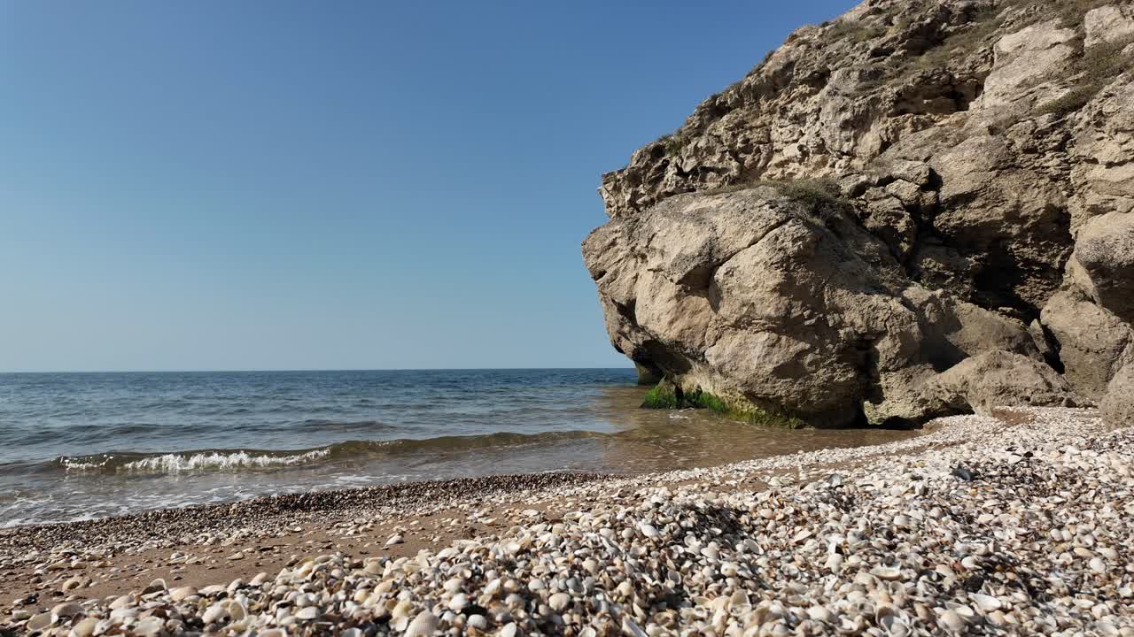 Rocky Cliff and Shell-Strewn Beach by the Sea