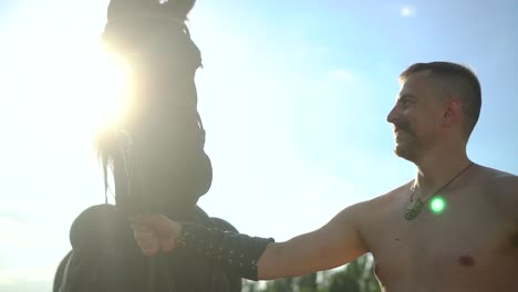 a man stands near a horse in a field 06