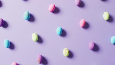 Close-up-of-multiple-colorful-easter-eggs-on-purple-background