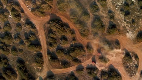 wide aerial shot of two four wheelers racing on the winding trails of cavo greko